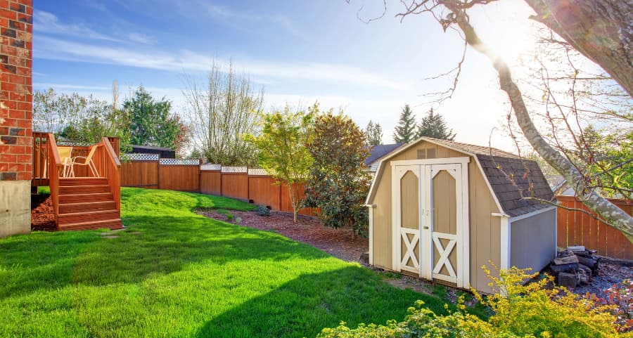 Fenced backyard with storage shed in Ogden